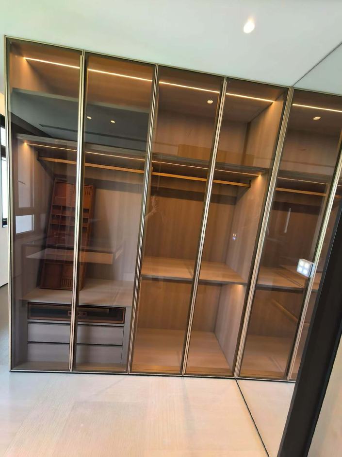 Walk-in wardrobe — glazed brass-framed fronts